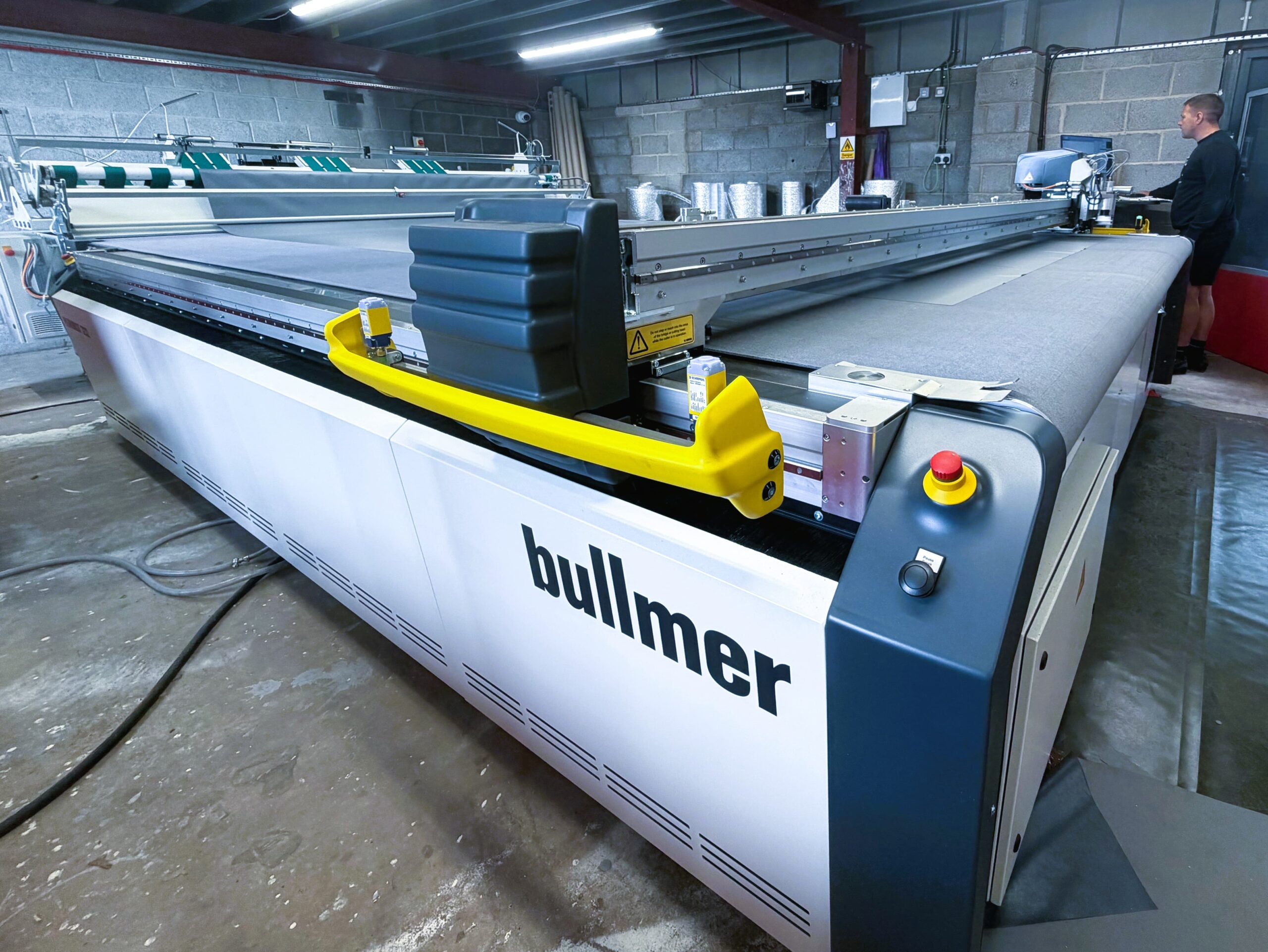 Large Bullmer digital cutting machine with a conveyor cutting table installed in a manufacturing facility.